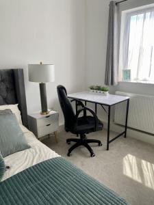 a bedroom with a desk and a chair and a bed at Portsmouth City Centre Modern Apartment - with Free Parking in Portsmouth
