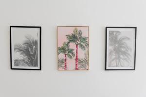 three framed palm trees on a wall at Portsmouth City Centre Modern Apartment - with Free Parking in Portsmouth