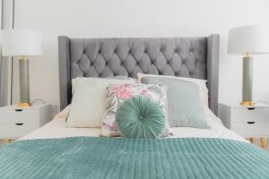 a bedroom with a bed with a green comforter and pillows at Portsmouth City Centre Modern Apartment - with Free Parking in Portsmouth