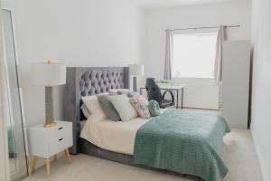 a bedroom with a bed and a lamp and a table at Portsmouth City Centre Modern Apartment - with Free Parking in Portsmouth