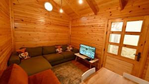 una sala de estar con sofá en una cabaña de madera en شاليه سبرينج للعائلات Spring, en King Abdullah Economic City