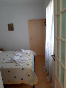 a bedroom with a bed and a window and a door at Lemon Garden 2 in Karídhion