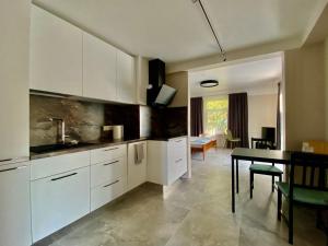 a kitchen with white cabinets and a table and a dining room at Skolas iela , Valmiera in Valmiera