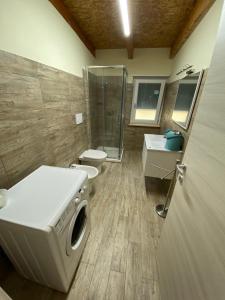 a bathroom with two toilets and a shower and a washing machine at LA CASA DI GIORGIO in Lamezia Terme