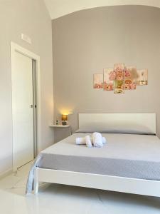 a white bedroom with a bed with towels on it at Sole apartments in Sarno