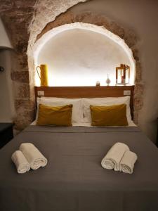 una camera da letto con un letto con due asciugamani sopra di A Petre Luxury Room a Cisternino