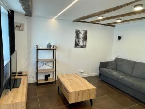 ルゼにあるStudio de charme proche Nantes & aéroport au calmeのソファとテーブルのあるリビングルーム