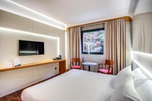 サロンノにあるHotel Della Rotondaのベッドとテレビ付きのホテルルーム