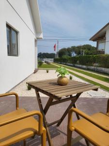 una mesa de madera y 2 sillas en el patio en Villa Ria en Ovar