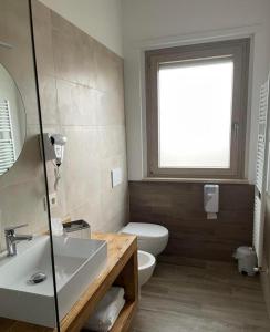 a bathroom with a sink and a toilet and a window at Why Not B&B in San Polo Matese