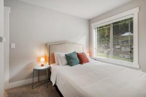 a white bedroom with a bed and a window at HoneyHomes Spectacular View Home with Amenities in Sumner