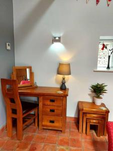 a room with a desk with a lamp and a chair at Luddie's Country Cottages - Poppy Cottage in Aislaby
