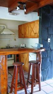 una cocina con barra y dos taburetes. en Cabañas Raimapu en Villa La Angostura
