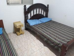 un lit avec deux oreillers bleus dessus dans une chambre dans l'établissement Casa em Olímpia, à Olímpia