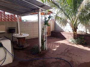 une terrasse avec une table et un palmier dans l'établissement Casa em Olímpia, à Olímpia