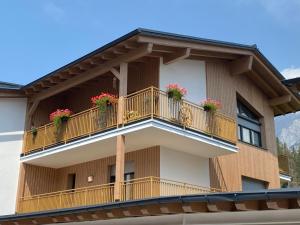 a building with two balconies with flowers on it at Moderne Kaminstube in Ramsau am Dachstein