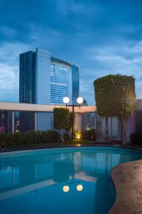 a pool on the roof of a building with a city at Hotel Casa Blanca in Mexico City