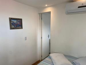 a bedroom with a bed and a picture on the wall at Loft container central c/ estacionamento in Pelotas