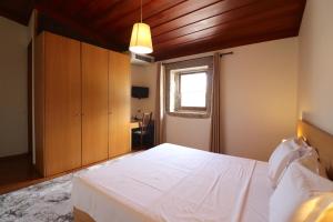 a bedroom with a bed and a lamp in it at Hotel Rural Alves - Casa Alves Torneiros in Penso