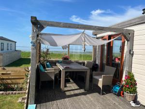 patio con tavolo e sedie su una terrazza di Chalet Meerblick Wattenmeer a Westerland