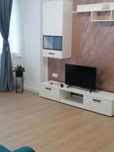 - un salon avec une télévision sur un centre de divertissement blanc dans l'établissement Locatia perfecta in centru, à Cluj-Napoca