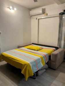 ein Schlafzimmer mit einem Bett mit einer gelben Decke darauf in der Unterkunft Un P’tit Coin de Nature in Sainte-Anne