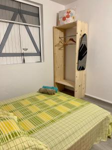 a bedroom with a bed and a shelf and a window at Un P’tit Coin de Nature in Sainte-Anne
