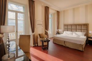 a hotel room with a bed and a large window at GH Palazzo Suite & SPA in Livorno