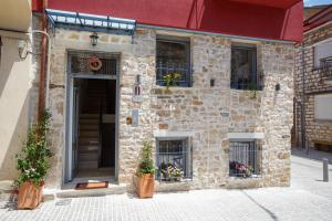 a stone building with flower pots in front of it at ΟNIRO Comfort Living in Ioannina