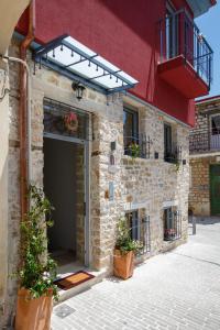 a building with a garage with potted plants on it at ΟNIRO Comfort Living in Ioannina