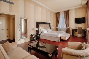 a hotel room with a bed and a living room at GH Palazzo Suite & SPA in Livorno