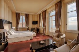 a large hotel room with a bed and a couch at GH Palazzo Suite & SPA in Livorno