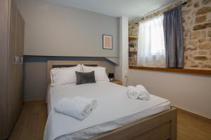 a bedroom with a bed with towels on it at ΟNIRO Comfort Living in Ioannina