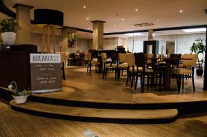 ein Restaurant mit Stühlen und Tischen in einem Gebäude in der Unterkunft Fletcher Hotel-Restaurant Weert in Weert