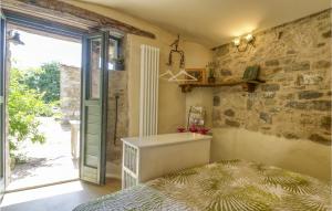a bedroom with a bed and a stone wall at 1 Bedroom Gorgeous Apartment In Villagrande Di Monteco 