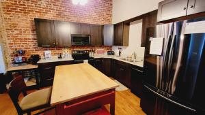 cocina con mesa de madera y nevera en Family-Friendly 3 bedroom in Historic building!, en Lynchburg