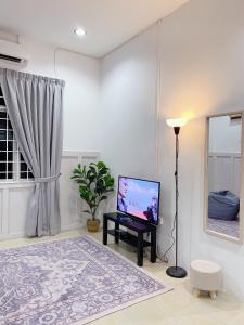een woonkamer met een flatscreen-tv op een tafel bij Zenhomes, The Raissa in Kota Bharu