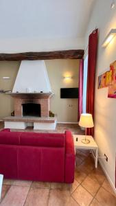 un soggiorno con divano rosso e camino di Suites Mansion a Rozzano