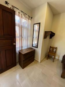 a room with a wooden door and a chair at Casa Tequio in San Cristóbal de Las Casas