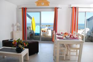 ミミザン・プラージュにあるRésidence Néméa Les Gourbetsのリビングルーム(テーブル、椅子付)が備わり、海の景色を望めます。
