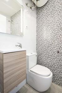 a bathroom with a toilet and a sink and a mirror at Cuidadosamente decorado apartamento junto al metro in Madrid