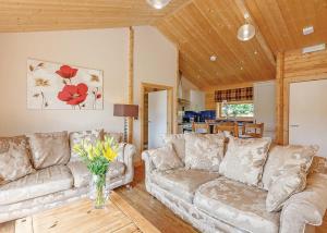 a living room with two couches and a vase of flowers at Gadlas Park Holiday Cabins in Ellesmere