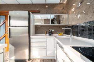 a kitchen with white cabinets and a stainless steel refrigerator at Villa Luxury Rock Tirri in Reus