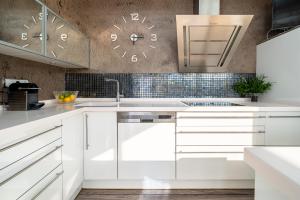 a kitchen with white cabinets and a clock on the wall at Villa Luxury Rock Tirri in Reus +61 photos