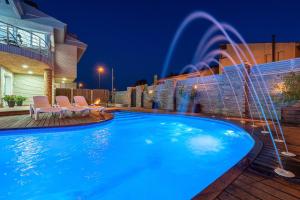 a swimming pool with a fountain in a backyard at night at Villa Luxury Rock Tirri in Reus