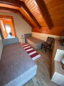 a bedroom with a bed and a chair in a room at Aranypatkó Vendégház Lovasudvar in Berzence