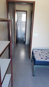 Zimmer mit einem Bett und einem Flur mit einem Bad in der Unterkunft Residencial Albatroz in Caraguatatuba