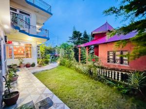 a house with a lawn in front of it at Grand view lodge and Restaurant Dharamshala - Partial Prepayment required to confirm booking in Dharamshala