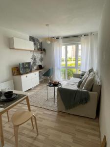 uma sala de estar com um sofá e uma mesa em Capsule Océan, à moins de 10 min de la plage em Aytré