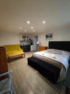 sypialnia z dużym łóżkiem i żółtą ławką w obiekcie Auberge Le Chata w mieście Saint-Georges-de-Didonne